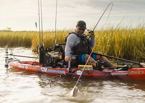 angler with a fish on the line in the flats in a yupik jackson kayak